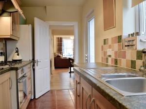 uma cozinha com um lavatório e uma bancada em Gilberts Warrant em Keswick
