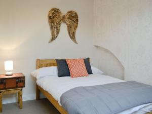 1 dormitorio con 1 cama con arco en la pared en Gilberts Warrant, en Keswick