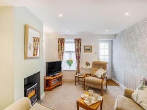 uma sala de estar com lareira e televisão em Quince Cottage em Flookburgh