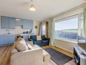 a living room with a couch and a kitchen at Surfers Hideaway in Woolacombe