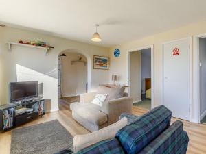 a living room with a couch and a tv at Surfers Hideaway in Woolacombe