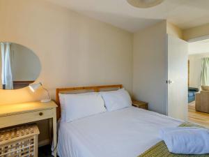 a bedroom with a bed and a dresser and a mirror at Surfers Hideaway in Woolacombe