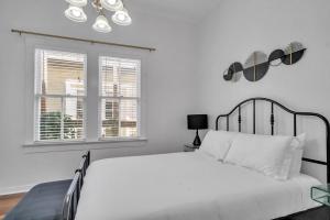 a white bedroom with a large bed and a window at Heart of Ybor City 3bedroom walk to 7th ave in Tampa