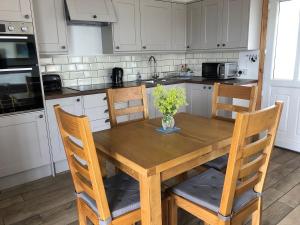 a kitchen with a wooden table with a vase of flowers on it at Clover Cottage in Sollas