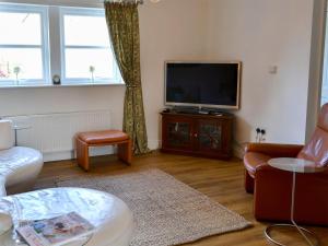 a living room with a couch and a tv at Castle Holt in Otterburn