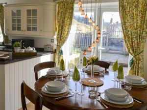 uma sala de jantar com uma mesa com pratos e copos de vinho em Castle Holt em Otterburn