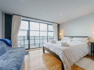 a bedroom with a bed and a large window at Ystwyth House in Borth