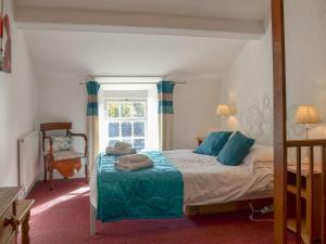 a bedroom with a bed with blue pillows and a window at Cosy Nook in Ambleside