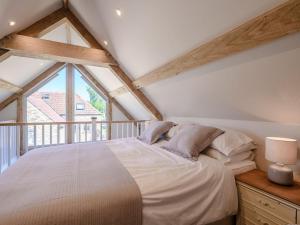 a bedroom with a bed and a large window at The Old Stable in Chew Stoke