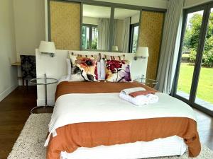 1 dormitorio con 1 cama grande y espejo grande en Mary's Tranquil B&B, en Whangarei