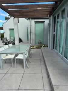 a glass table and chairs on a patio at Mary's Tranquil B&B in Whangarei