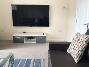 a living room with a couch and a flat screen tv at Deany Apartment in Bridlington