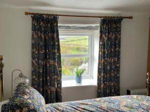 um quarto com uma cama e uma janela em Penny Black Cottage em Ingleton