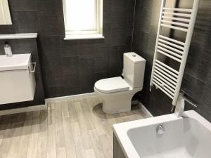 a bathroom with a white toilet and a sink at Deany Apartment in Bridlington
