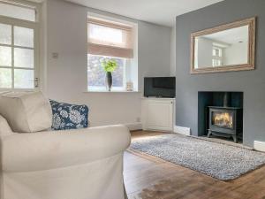 a living room with a couch and a fireplace at Holmfield in Buxton