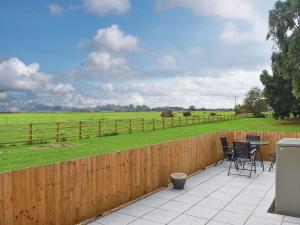 a patio with a table and chairs and a fence at Owl Cottage in Ryton