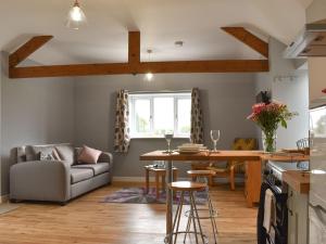 a kitchen and living room with a table and a couch at Owl Cottage in Ryton
