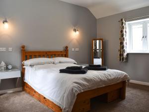 a bedroom with a large bed with two towels on it at Owl Cottage in Ryton