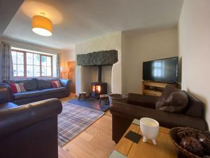 a living room with couches and a fire place at Hazelrigg Farm in Newby Bridge