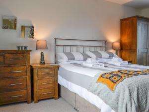 um quarto com uma cama grande com uma cómoda e uma mesa de cabeceira em Zonnebloem em Cefn-y-bedd