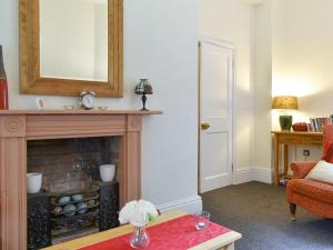a living room with a fireplace and a mirror at Smithy Lodge At Heaton Park in Manchester