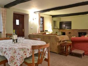 a living room with a table and a fireplace at Smithy House in Bampton
