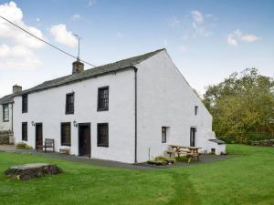 een wit gebouw met een picknicktafel ervoor bij Smithy House in Bampton