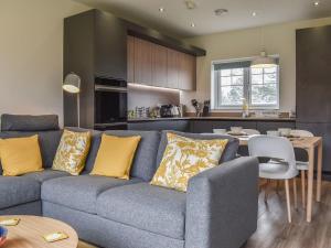 a living room and kitchen with a couch and a table at Hawthorn Cottage in Shirley