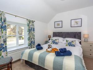 a bedroom with two beds and a window at Box Tree Cottage in Pickering