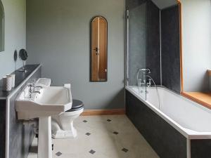 ein Badezimmer mit einem Waschbecken, einem WC und einer Badewanne in der Unterkunft Tor Aluinn in Skullomie