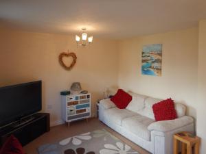 een woonkamer met een bank en een flatscreen-tv bij The Costal Hideaway in Sidmouth