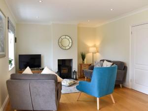 a living room with two couches and a blue chair at Crown Cottage in Danehill