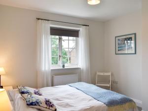 1 dormitorio con cama y ventana en Crown Cottage en Danehill