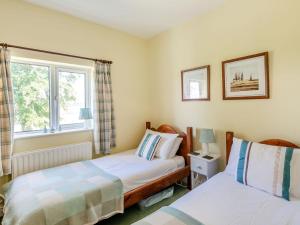 a bedroom with two beds and a window at Edlington Hall Cottage in Edlington