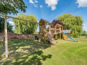 um parque infantil com um escorrega e um baloiço em Edlington Hall Cottage em Edlington