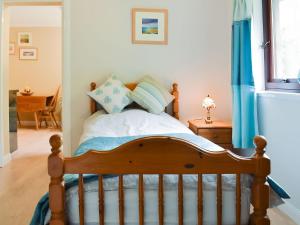 a bedroom with a bed with blue curtains and a window at Drummond Neuk in Brackley