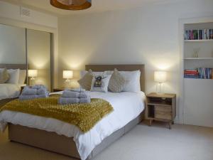 een slaapkamer met een groot bed met 2 kussens bij West Cottage in Fife