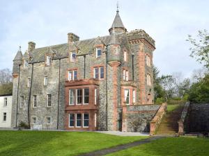 an old brick building with a staircase in front of it at Machermore Castle in Newton Stewart