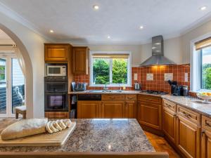 a kitchen with wooden cabinets and a counter top at The Reeds in Wroxham