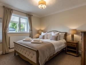 a bedroom with a bed with two towels on it at The Reeds in Wroxham