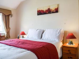 a bedroom with a bed with a red blanket on it at Serenity Comfort in Sutton Coldfield