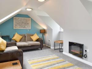 a living room with a couch and a fireplace at The Loft in Holwell