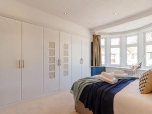 a white bedroom with a bed and a sink at Court House in Porthcawl