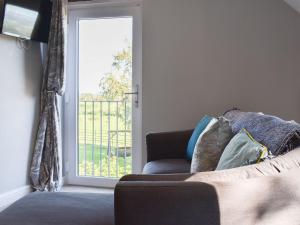 un soggiorno con divano e porta scorrevole in vetro di Treacle Cottage - Uk12912 a Warton