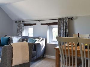 un soggiorno con divano e tavolo di Treacle Cottage - Uk12912 a Warton