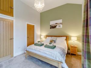 a bedroom with a bed with two pillows on it at Merry Burn Barn - Uk3325 in Falstone