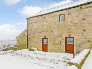 a brick building with two doors in the snow at Shepherds Nook - Uk32388 in Dunford Bridge