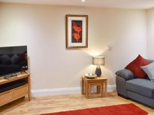 a living room with a couch and a tv at The Mews in Appleby