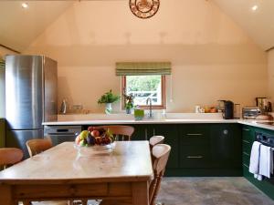 uma cozinha com uma mesa com uma taça de fruta em Cosy Cottage - Uk34263 em Fordingbridge