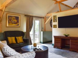 uma sala de estar com um sofá e uma televisão em Cosy Cottage - Uk34263 em Fordingbridge